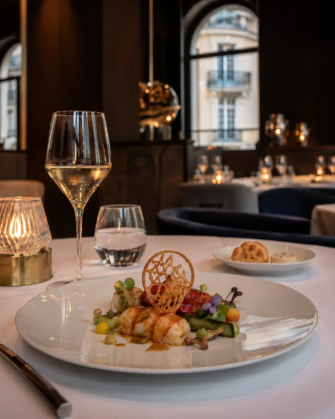 Dukade restaurangbord med vin och en skaldjursrätt